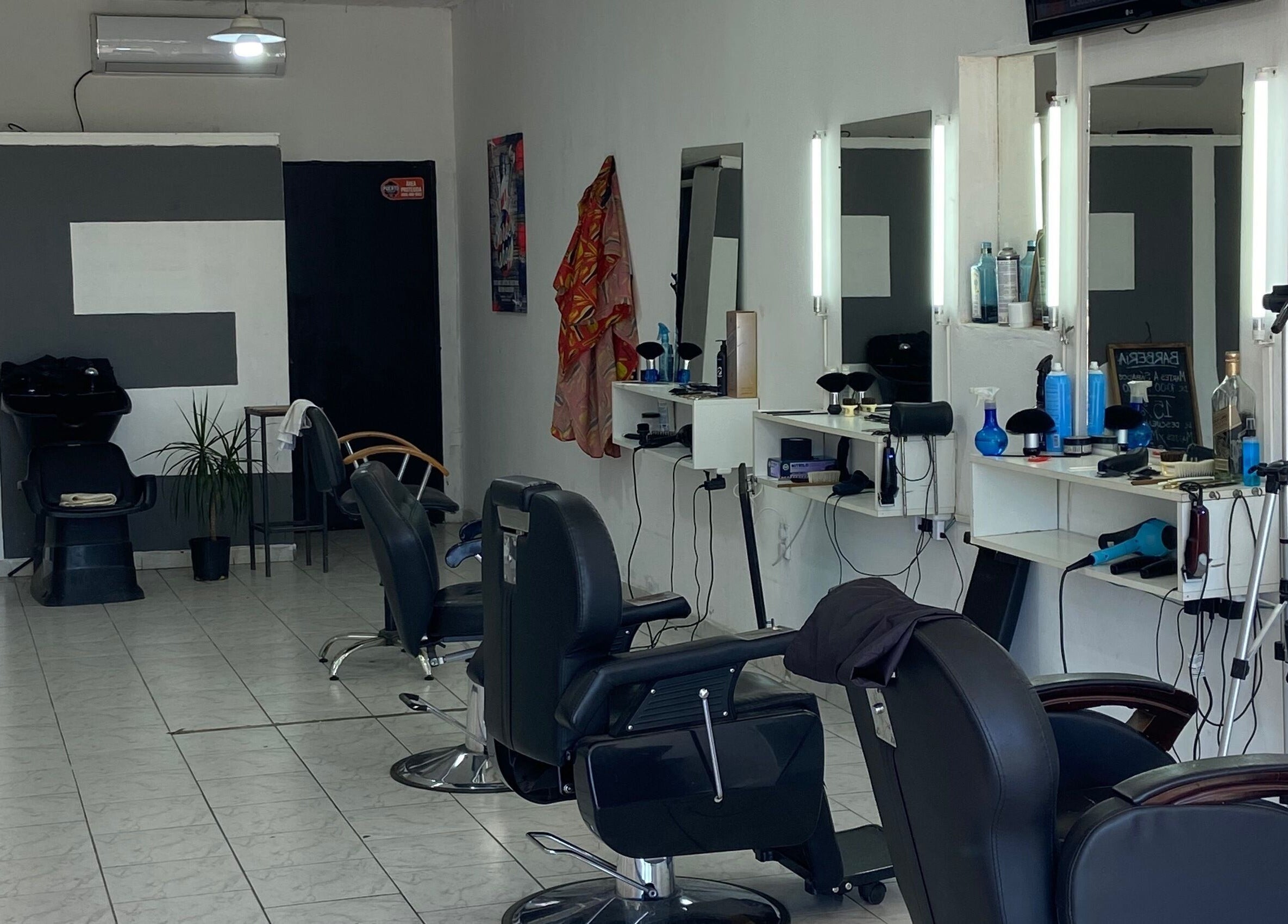 Interior de Texture Barbershop en Rosario, Santa Fe, AR, mostrando sillas y estaciones de estilismo.