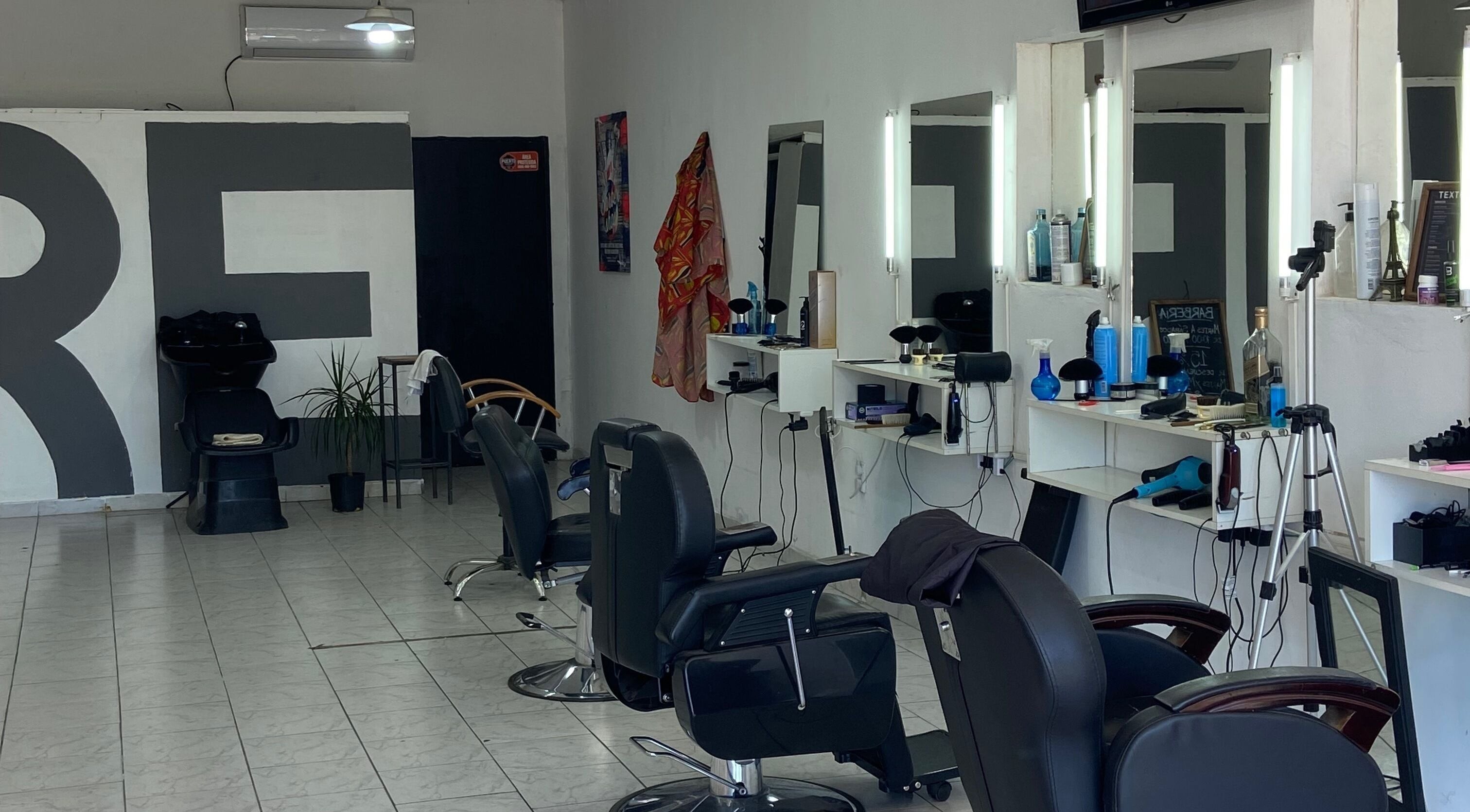 Interior de Texture Barbershop en Rosario, Santa Fe, AR, mostrando sillas y estaciones de estilismo.