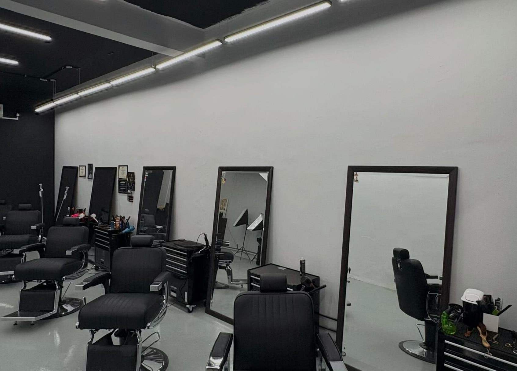 Interior of Brotherhud Barberhouse Perda, Bukit Mertajam, Pulau Pinang, MY: sleek black chairs, large mirrors.