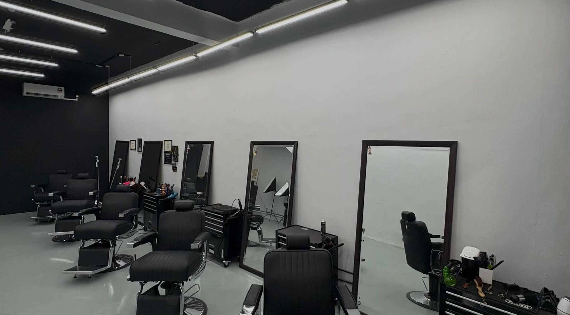 Interior of Brotherhud Barberhouse Perda, Bukit Mertajam, Pulau Pinang, MY: sleek black chairs, large mirrors.