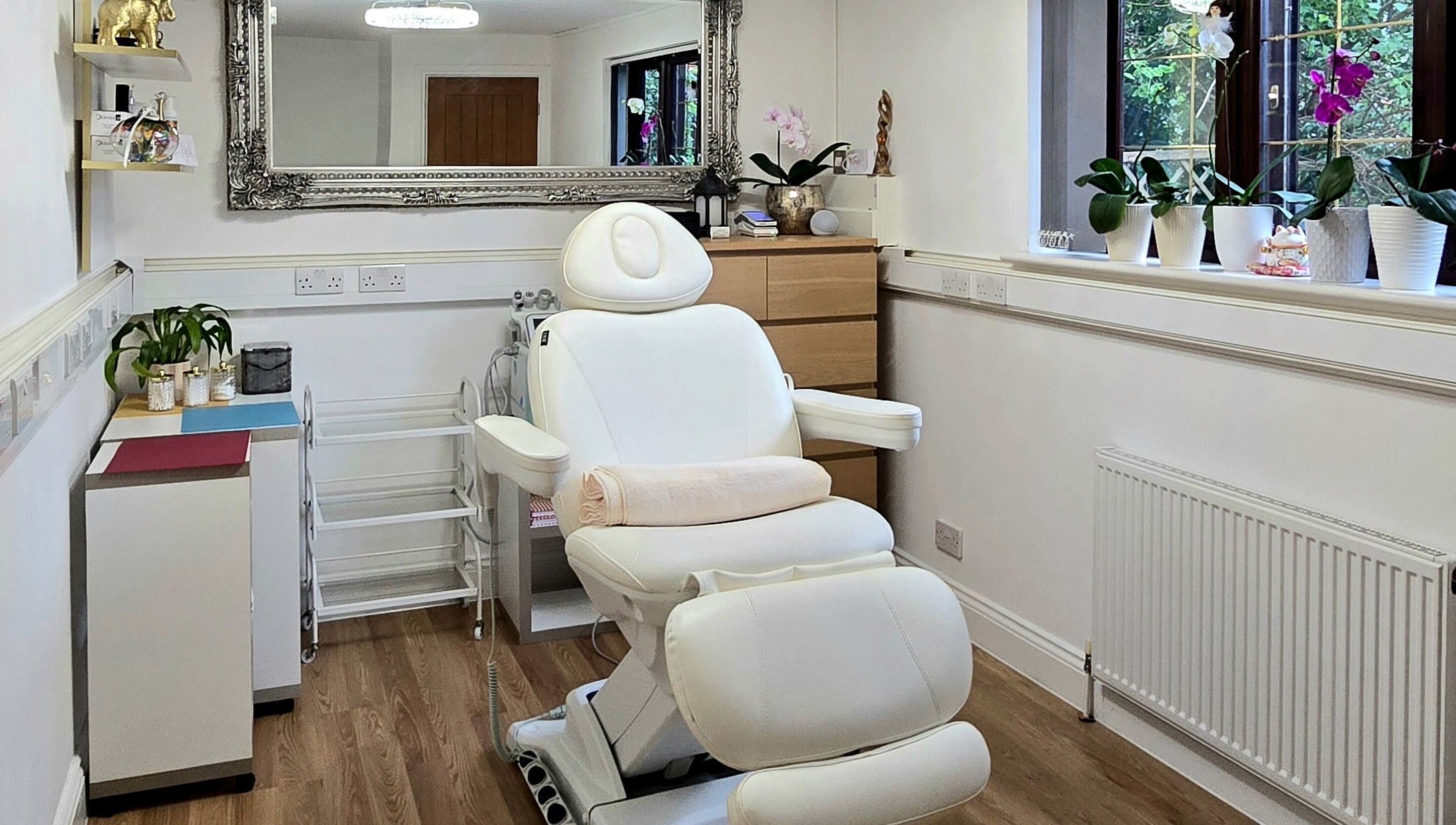 Relaxing treatment room at Amber Beauties in Goffs Oak, England, GB, featuring plush white chair and elegant decor.