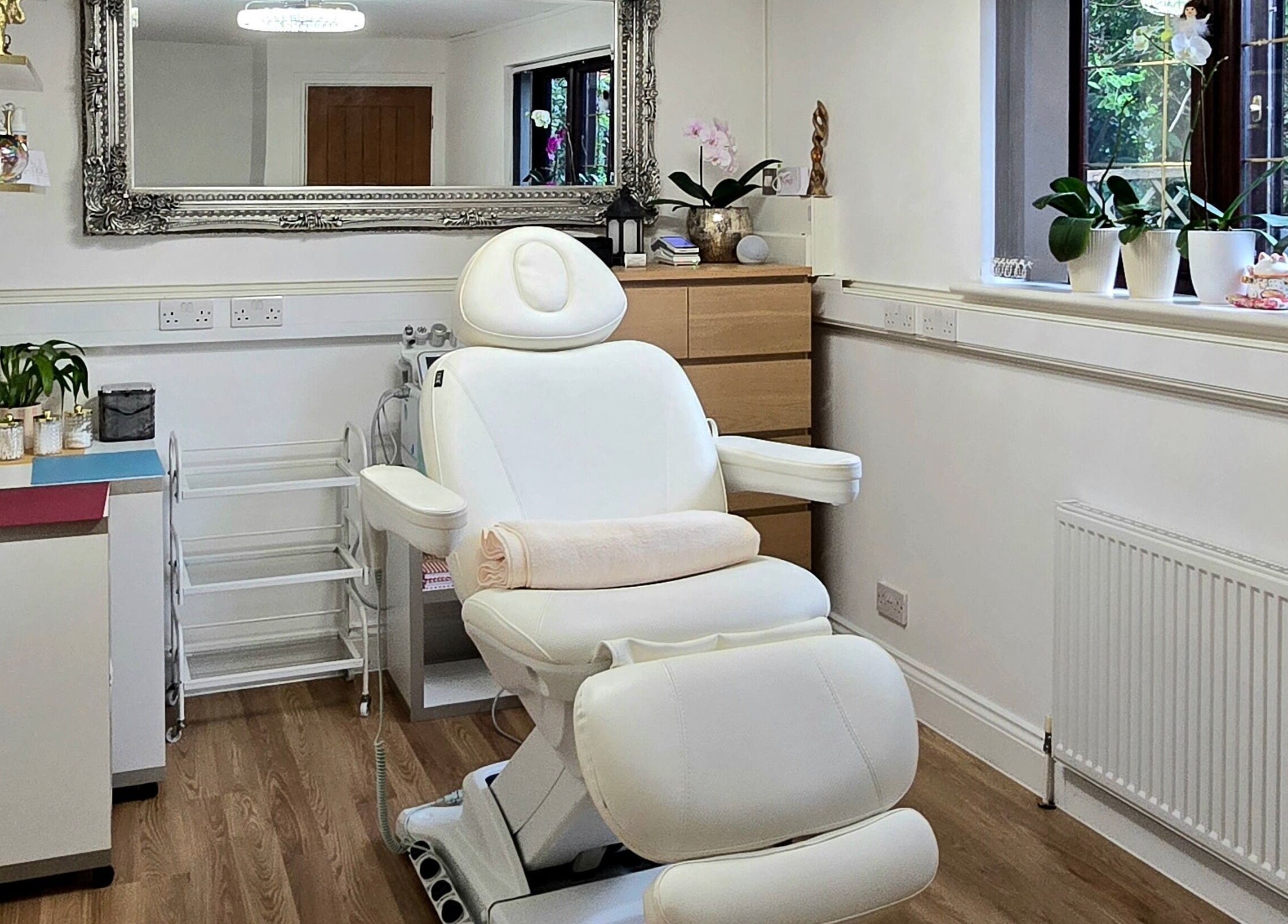 Relaxing treatment room at Amber Beauties in Goffs Oak, England, GB, featuring plush white chair and elegant decor.