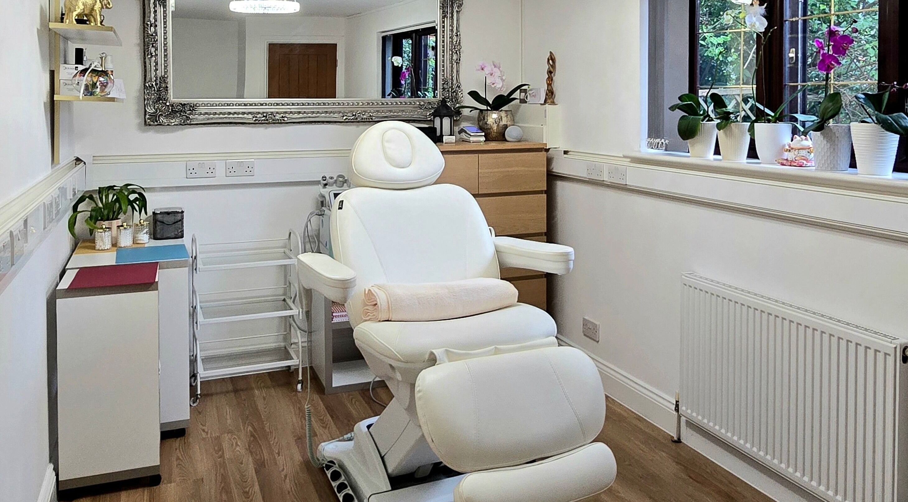 Relaxing treatment room at Amber Beauties in Goffs Oak, England, GB, featuring plush white chair and elegant decor.