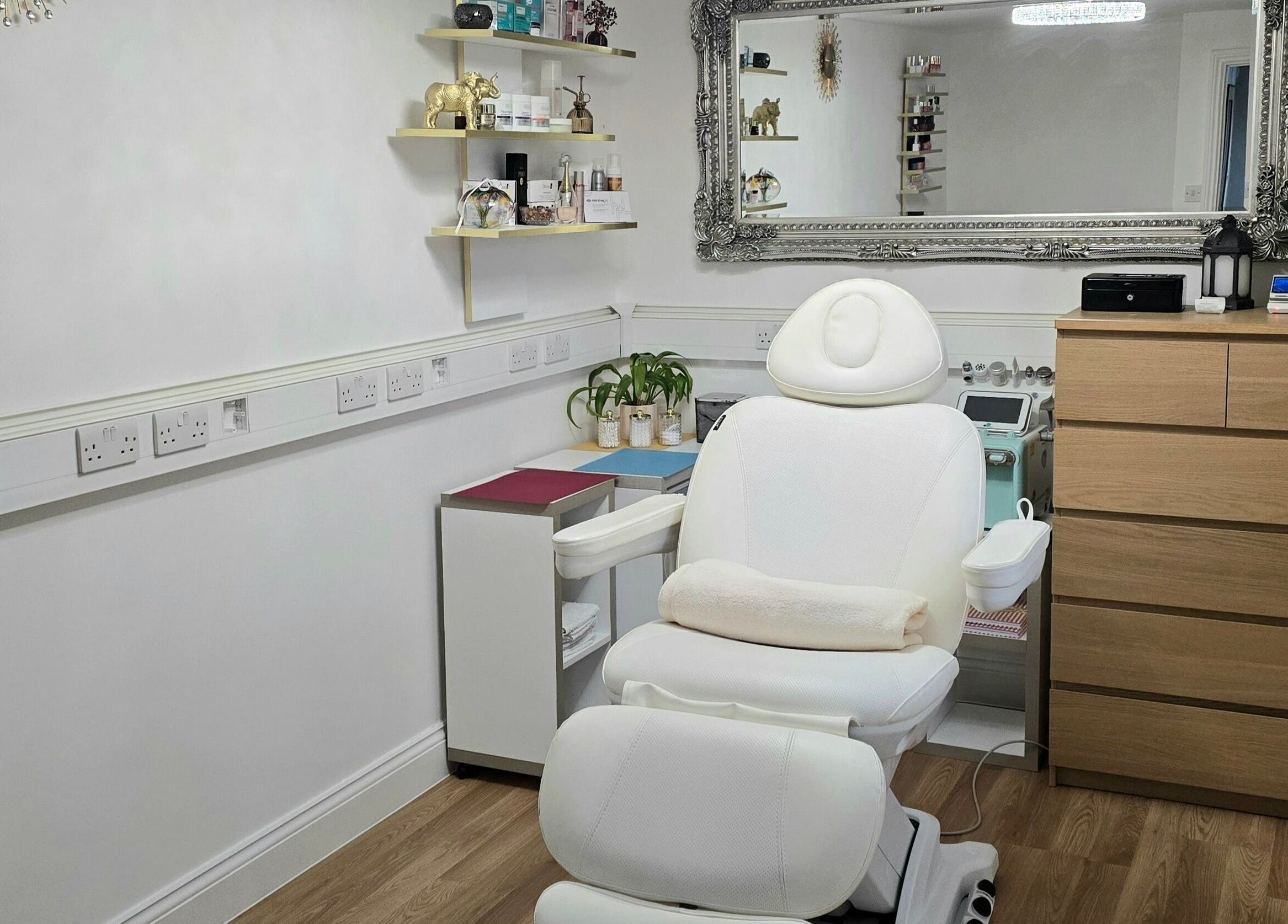 Amber Beauties' serene treatment room in Goffs Oak, England, GB, featuring a white chair and elegant decor.