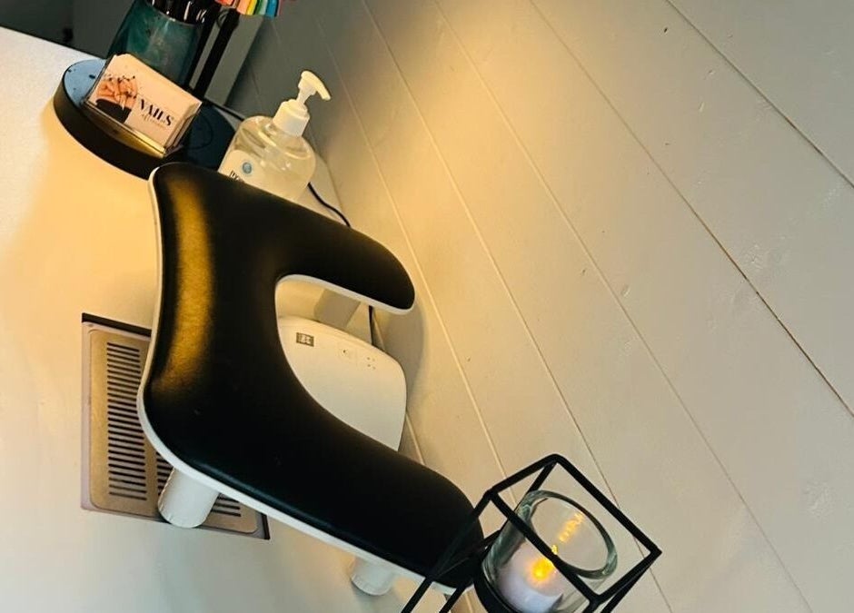 Nail care station at Blissful Touch, Bugle, England, GB featuring a comfy armrest and candle ambiance.