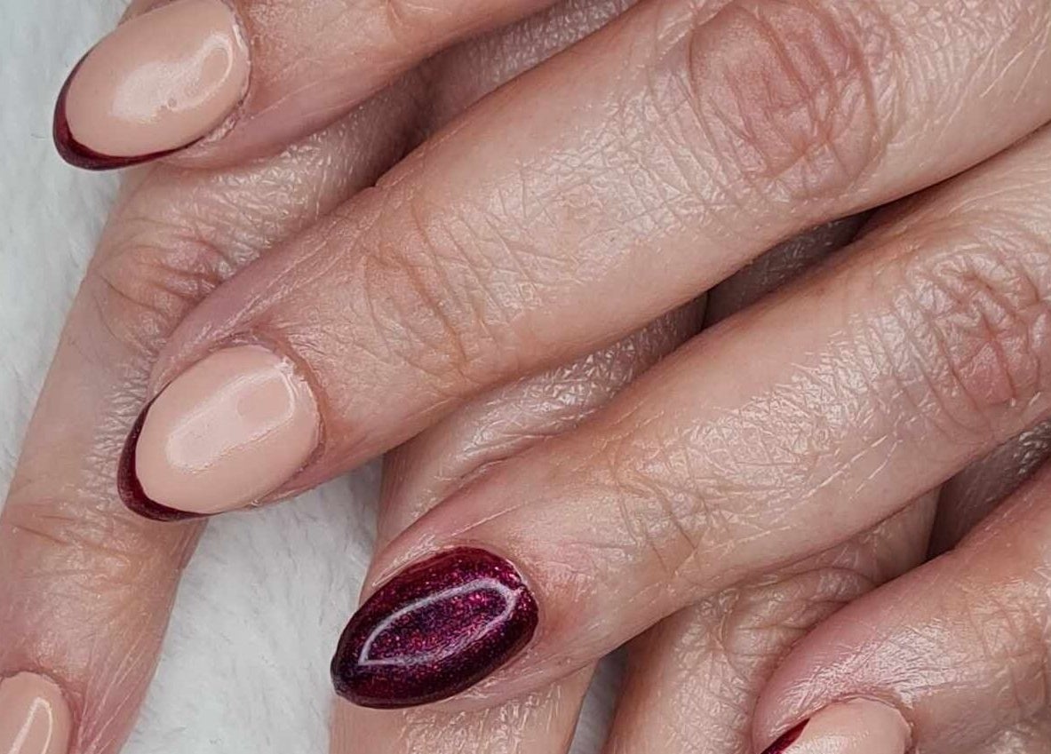 Close-up of artistic manicure at Blissful Touch in Bugle, England, GB, featuring nude and maroon tones.