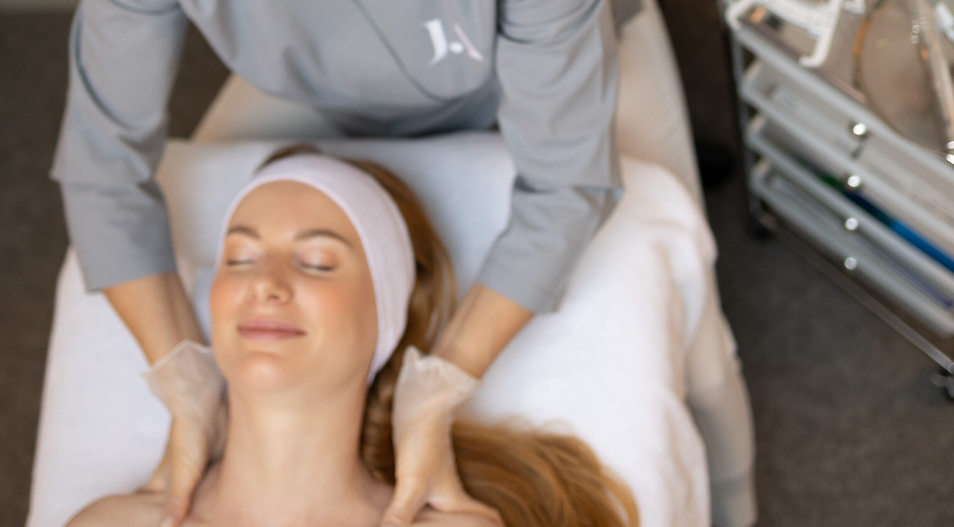 Client enjoying a soothing facial massage at Fitzrovia Aesthetics, London, England, GB.