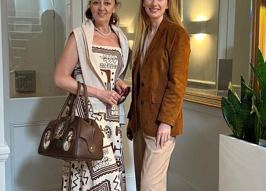 Two women smiling inside Fitzrovia Aesthetics, a stylish venue in London, England, GB.