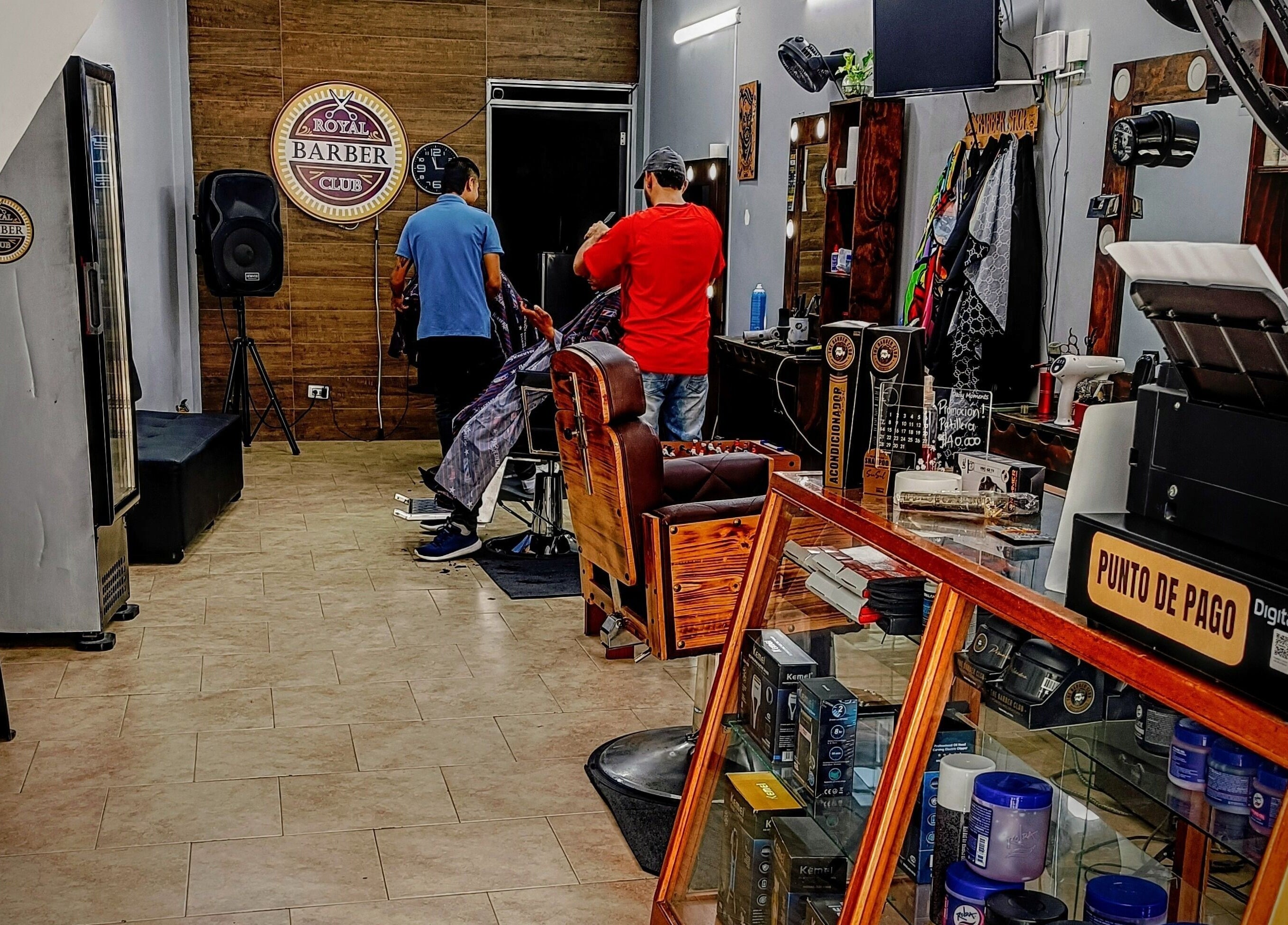 Interior de Royal Barber Club en Zarzal, Valle Del Cauca, CO mostrando estilista en acción.