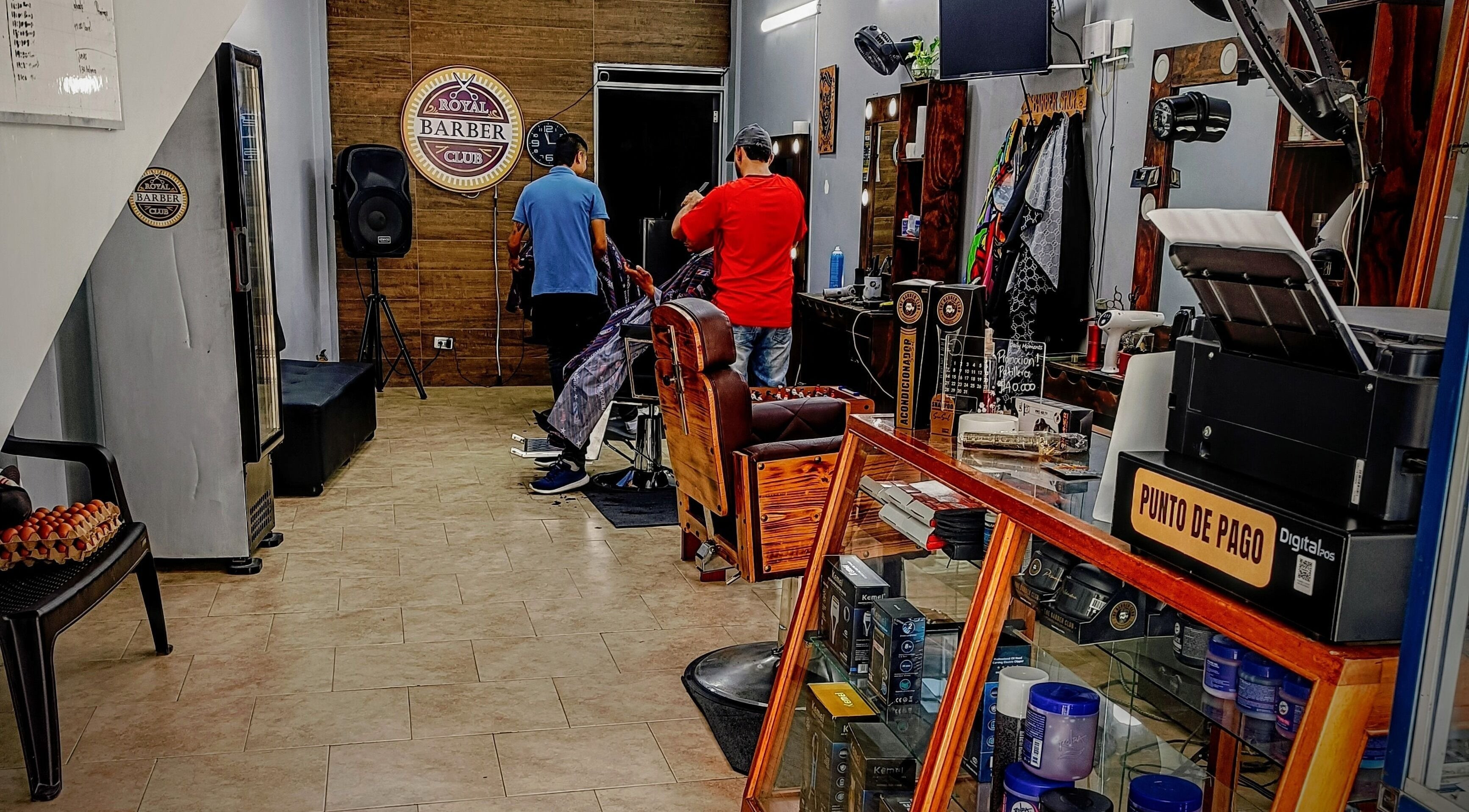 Interior de Royal Barber Club en Zarzal, Valle Del Cauca, CO mostrando estilista en acción.