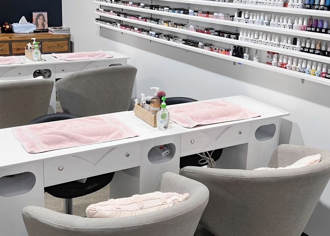 Coco Nails and Beauty nail stations in Auckland, Auckland, NZ featuring organized polish displays and cozy seating.