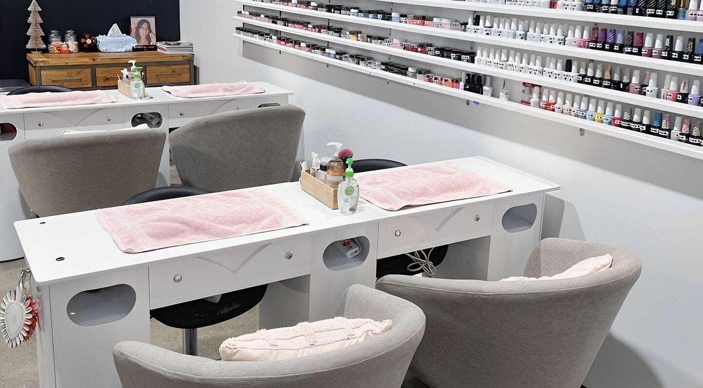 Coco Nails and Beauty nail stations in Auckland, Auckland, NZ featuring organized polish displays and cozy seating.