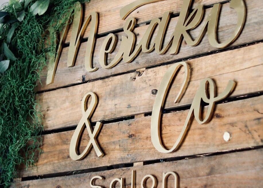 Wooden sign with elegant script for Meraki and Co Salon LLC in Greer, South Carolina, US.