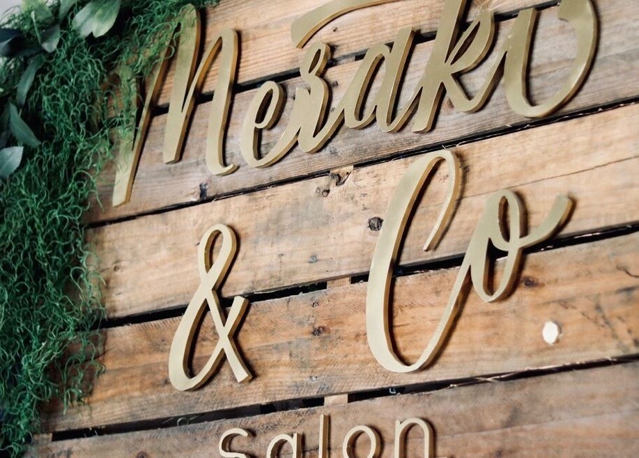 Wooden sign with elegant script for Meraki and Co Salon LLC in Greer, South Carolina, US.