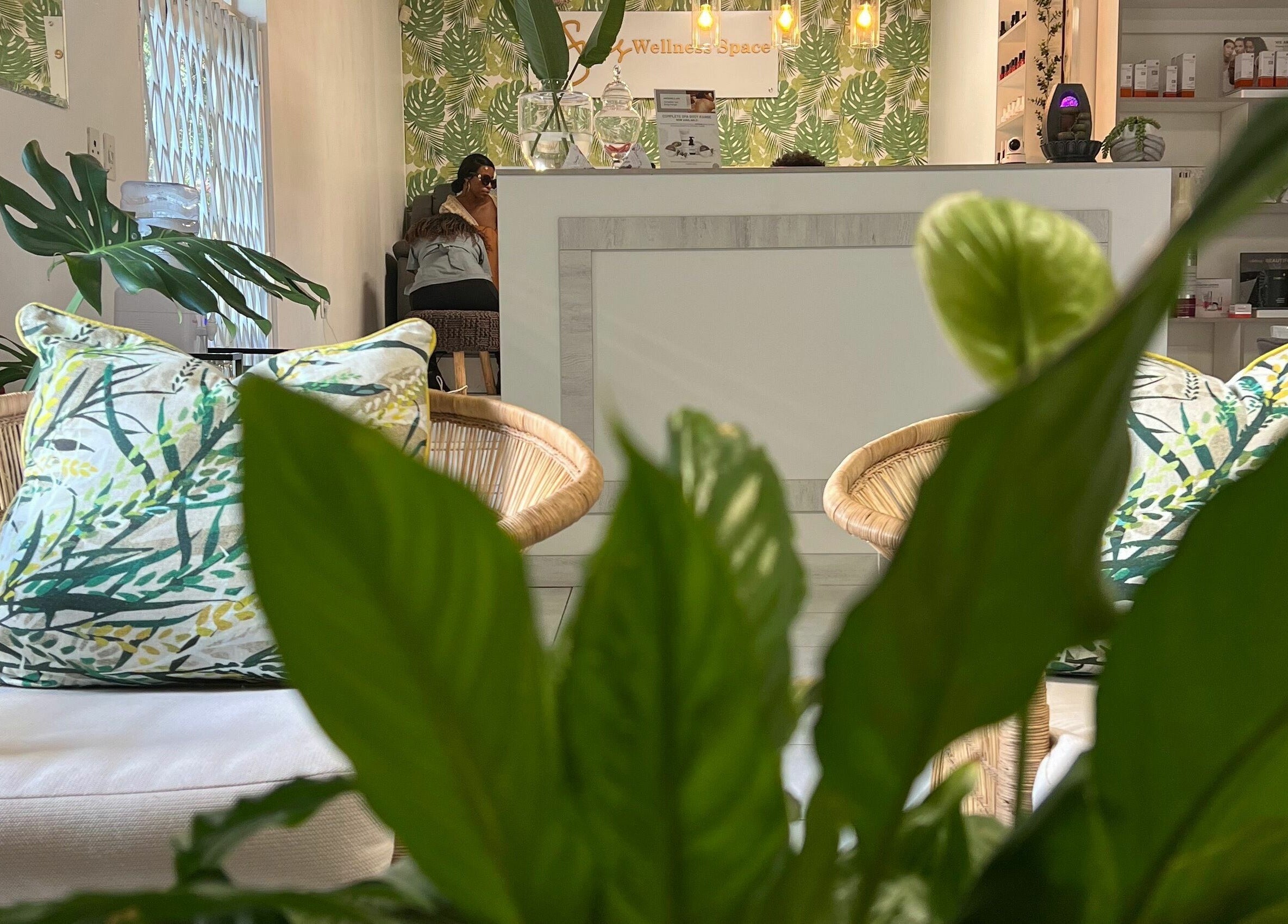 Serene seating at Snes Wellness Space in Sandton, Gauteng, ZA, surrounded by lush greenery and soft lighting.