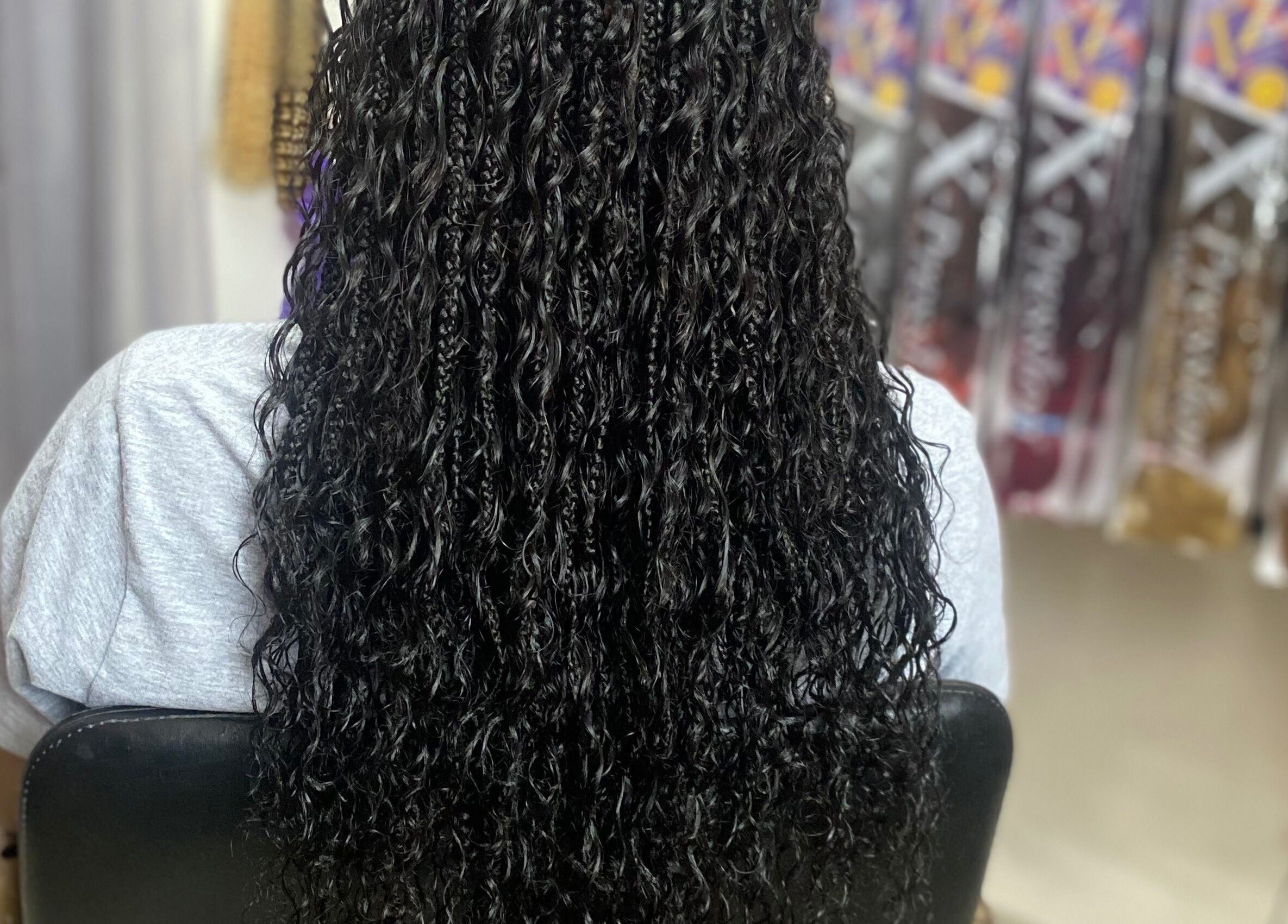 Long curly braids styled at Fro and Glo Beauty in Bridgetown, Saint Michael, BB showcasing texture and style.