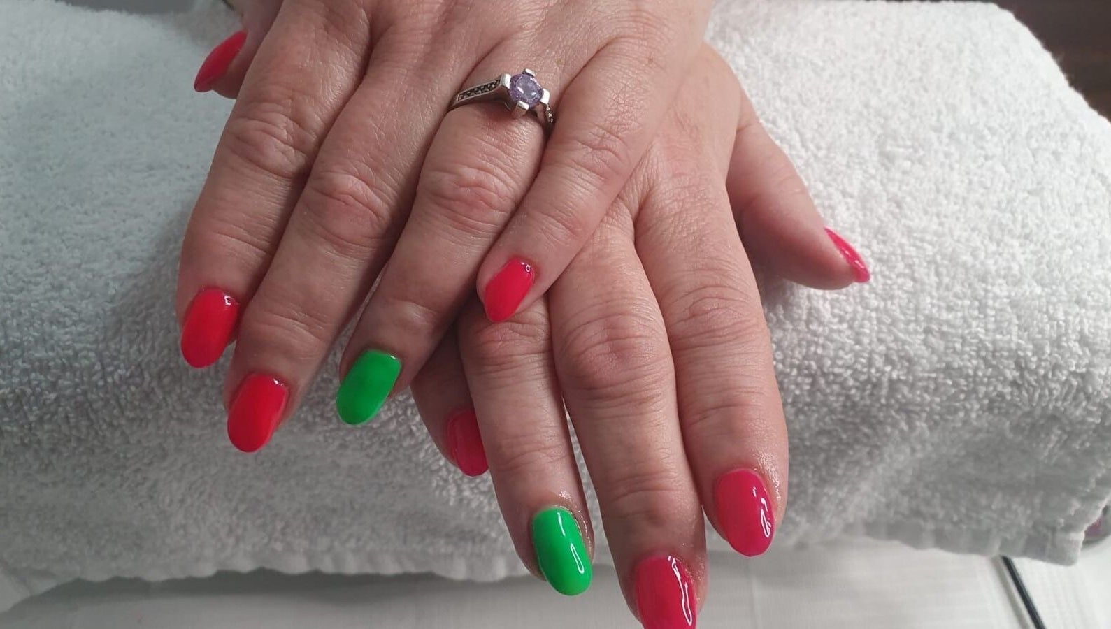 Bright red and green nails at Opulence Nails, Middle Sackville, Nova Scotia, CA on white towel.