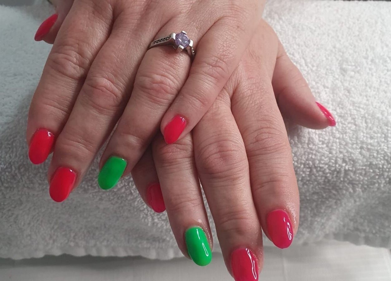 Bright red and green nails at Opulence Nails, Middle Sackville, Nova Scotia, CA on white towel.