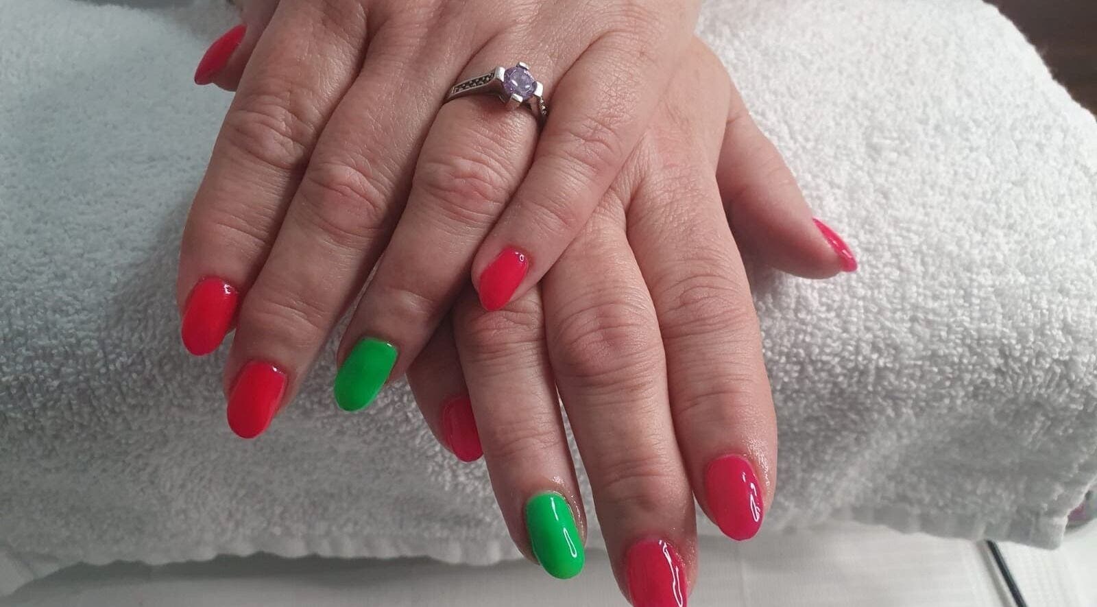 Bright red and green nails at Opulence Nails, Middle Sackville, Nova Scotia, CA on white towel.