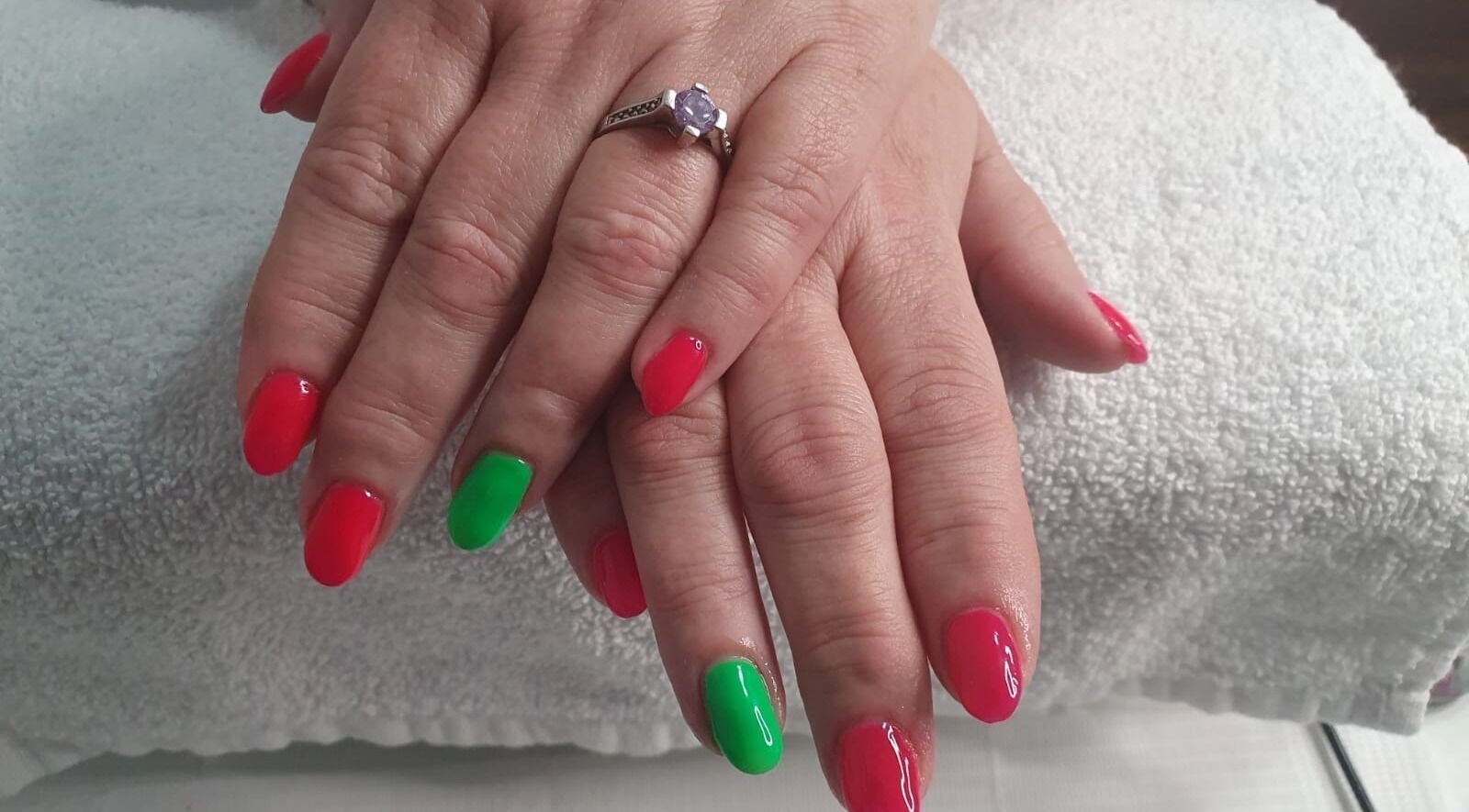 Bright red and green nails at Opulence Nails, Middle Sackville, Nova Scotia, CA on white towel.
