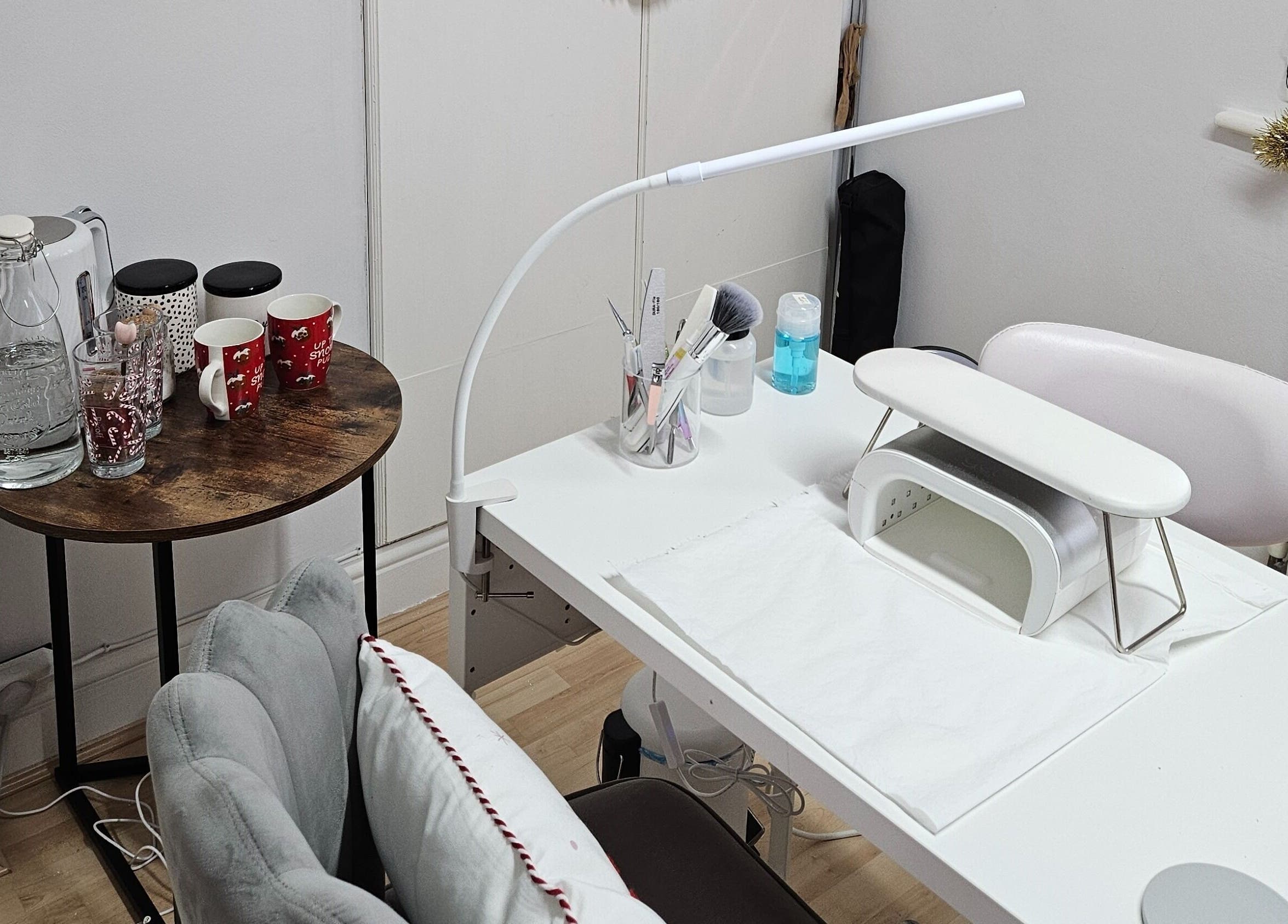 Nail treatment station at Nails by Verity, Tenterden, England, GB featuring a neat setup with beverages.