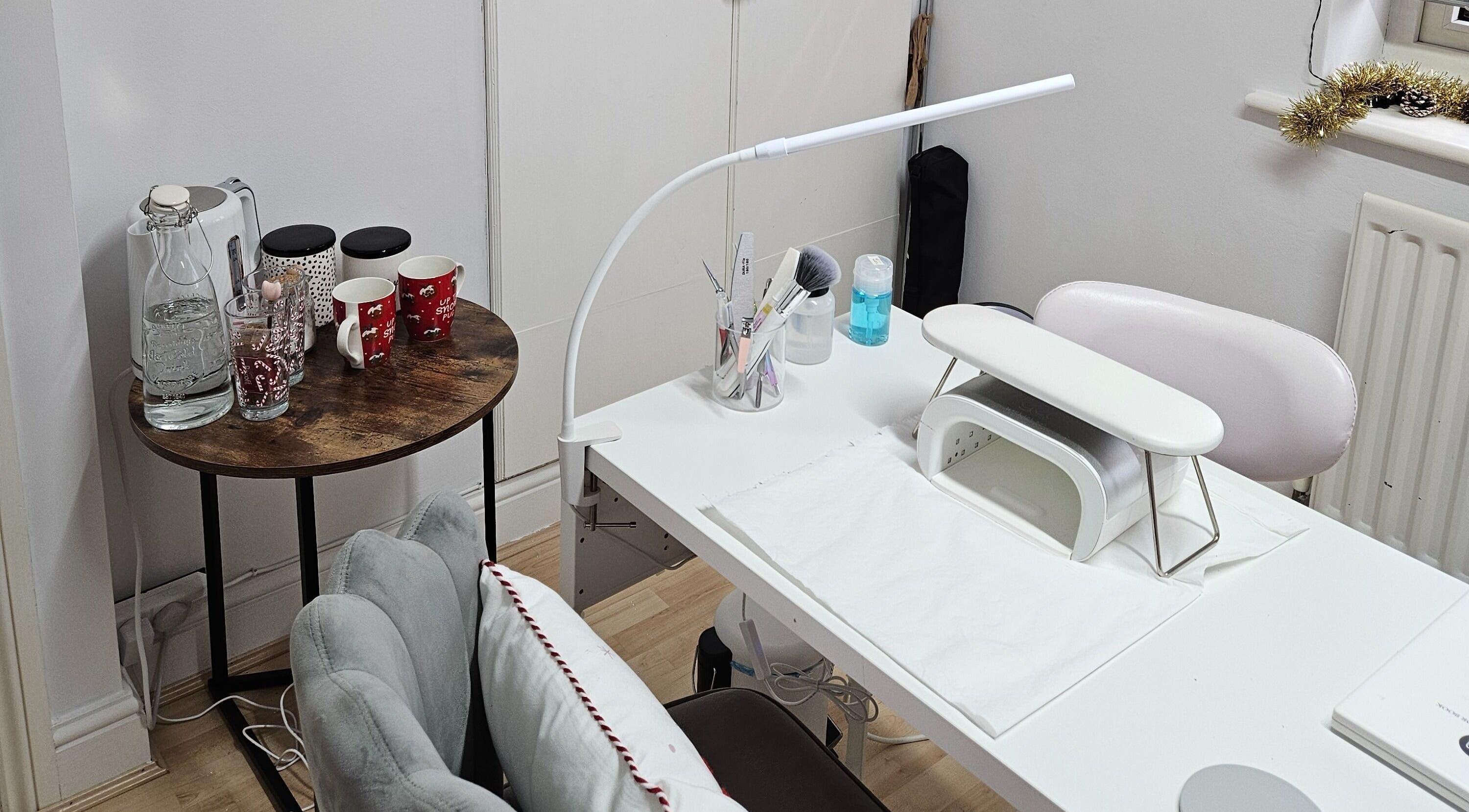 Nail treatment station at Nails by Verity, Tenterden, England, GB featuring a neat setup with beverages.