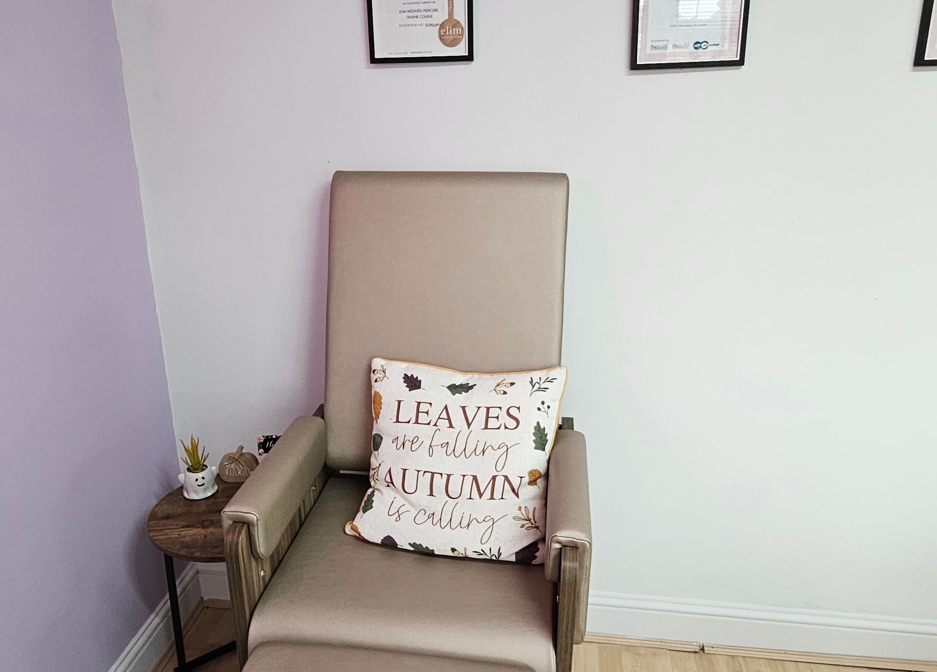 A comfy chair with an autumn-themed pillow at Nails by Verity, Tenterden, England, GB.