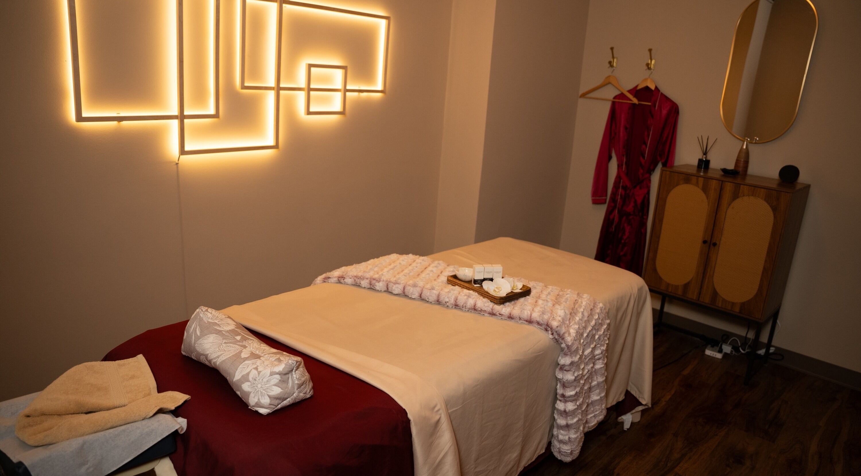 Relaxing treatment room at Luxsa Thai Spa, New York, New York, US, with ambient lighting and cozy decor.