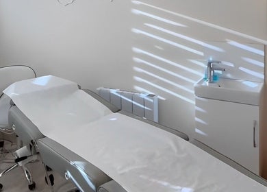 A clean treatment room at Katie Mai Beauty & Aesthetics, Stevenage, England, GB with a modern spa bed and sink.