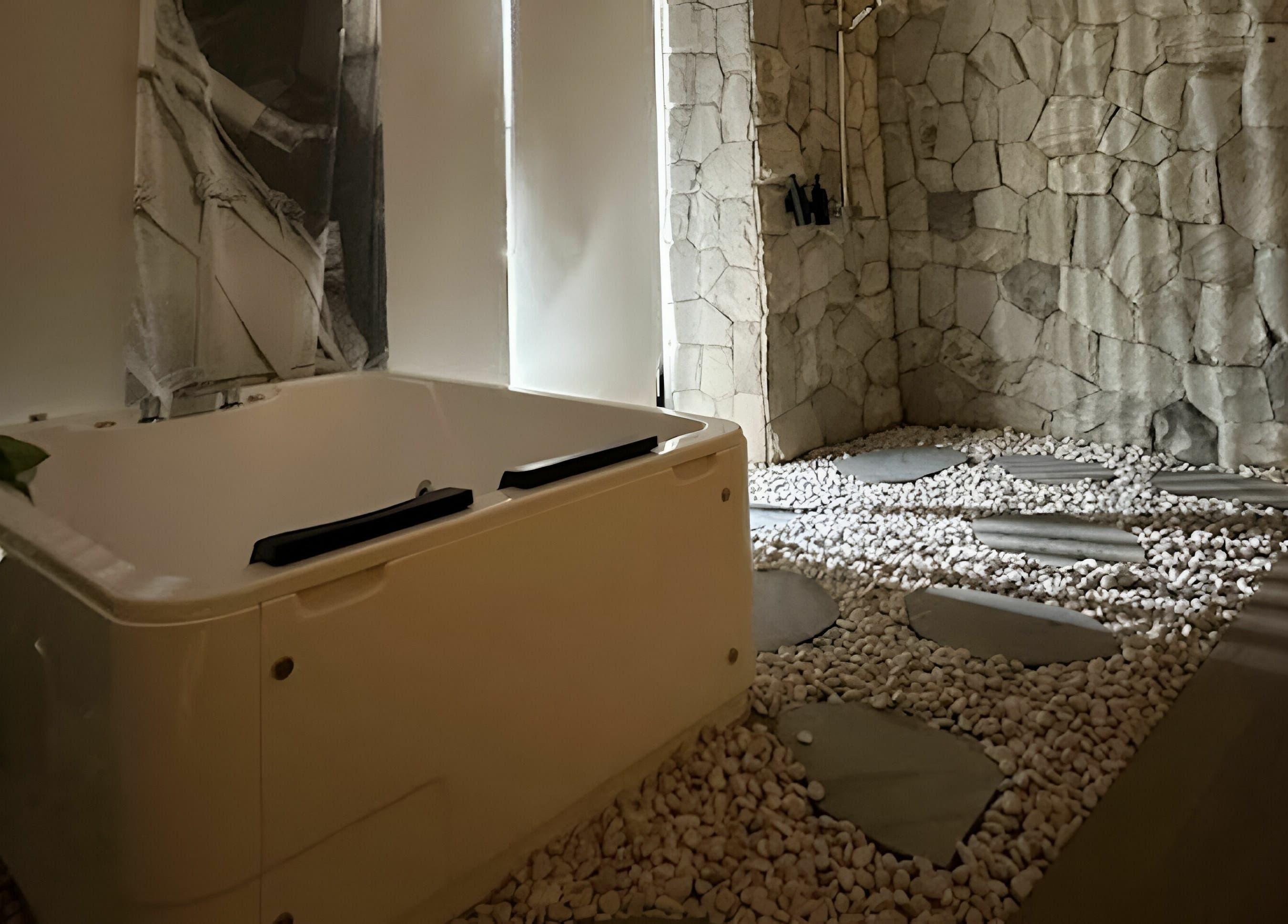 Luxurious spa room at Gaya Spa PIK in Banten, Banten, ID with a relaxing tub and serene stone decor.