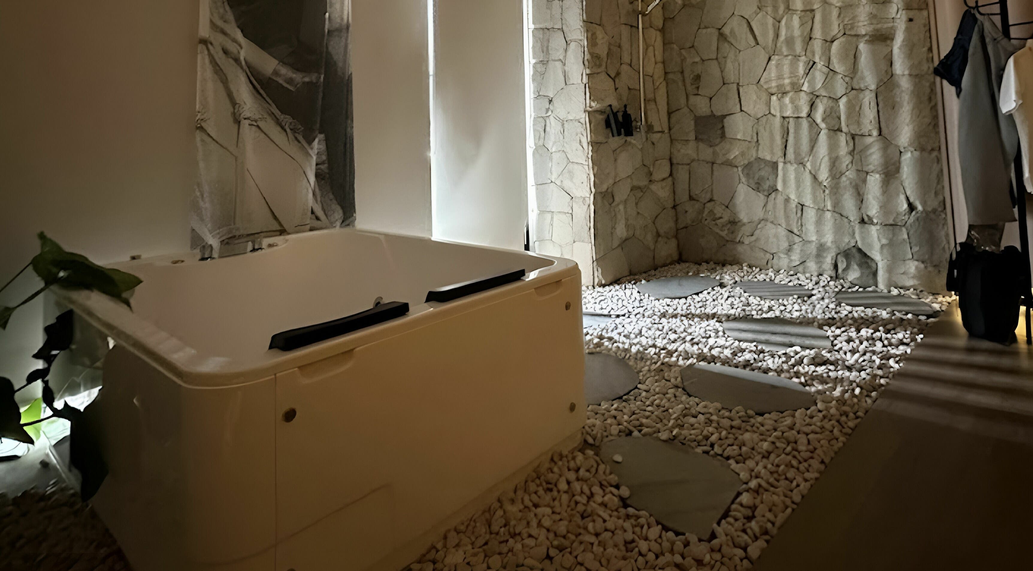 Luxurious spa room at Gaya Spa PIK in Banten, Banten, ID with a relaxing tub and serene stone decor.
