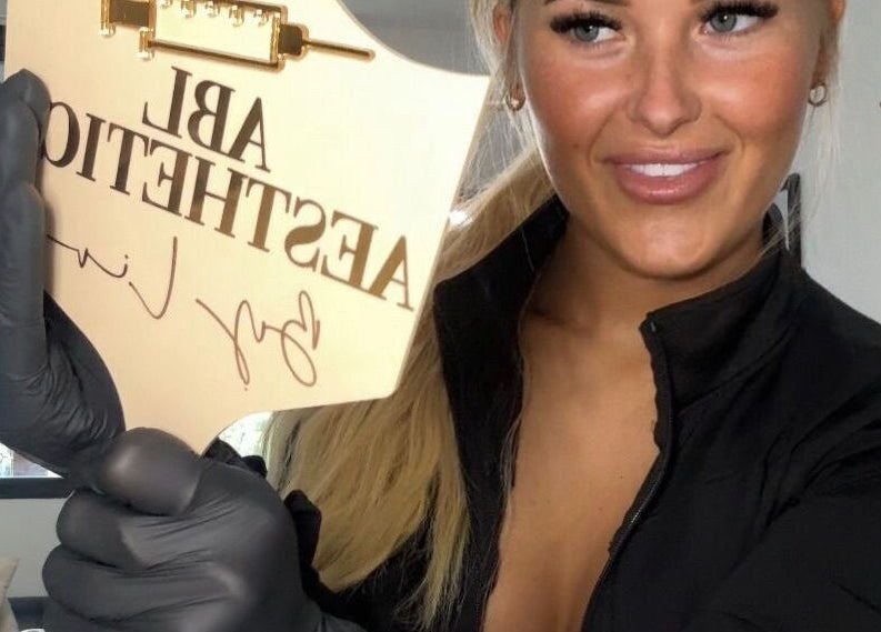 Award plaque at Liv Chapman Aesthetics & Nails in Watford, England, GB held by smiling individual.