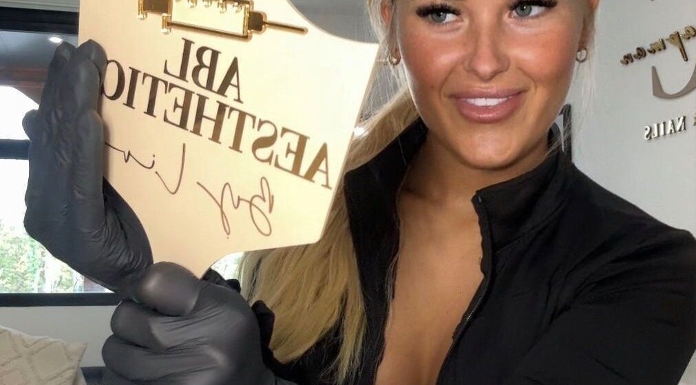 Award plaque at Liv Chapman Aesthetics & Nails in Watford, England, GB held by smiling individual.