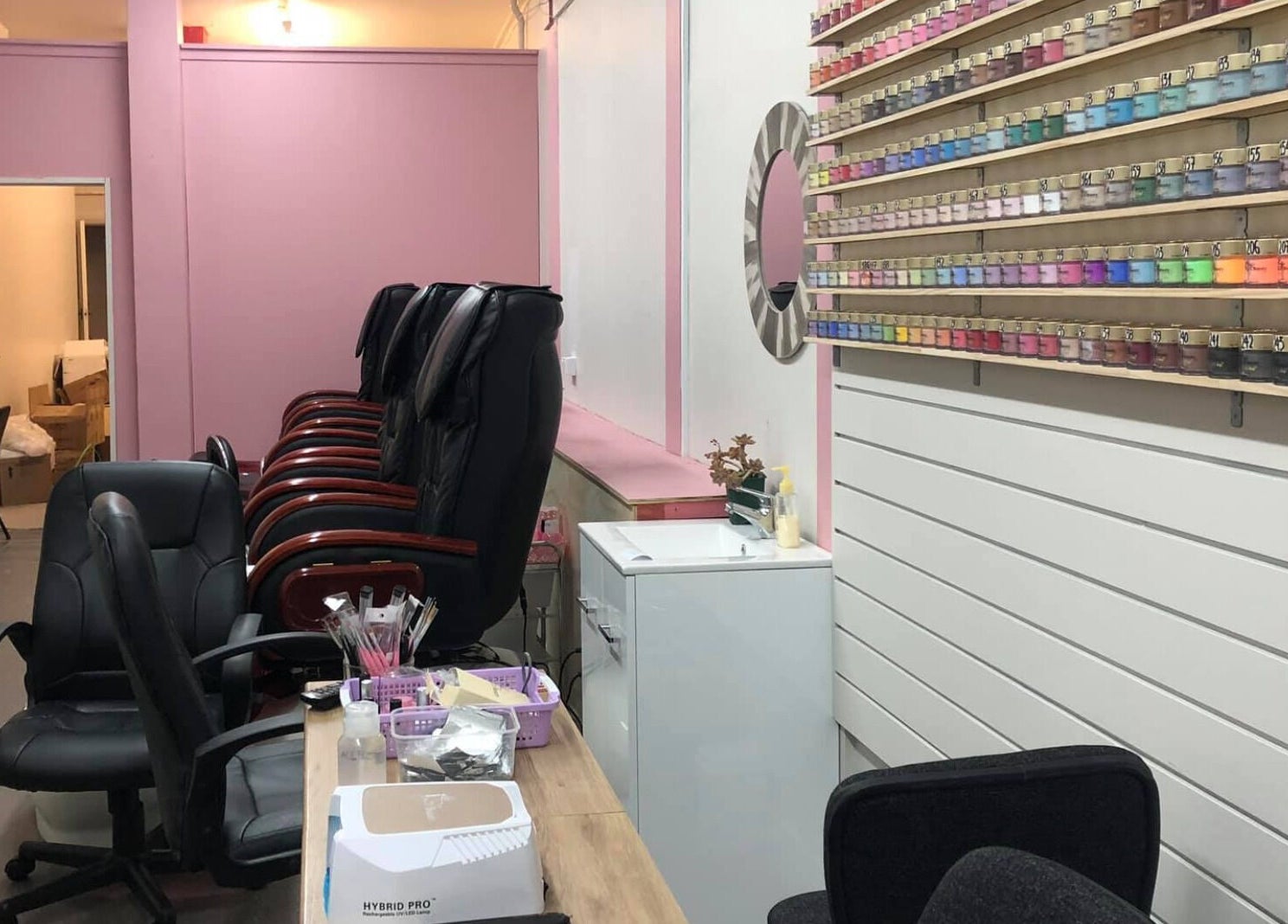 Interior of Ruby Nails, Palmerston North, with colorful nail polish display and comfortable seating.