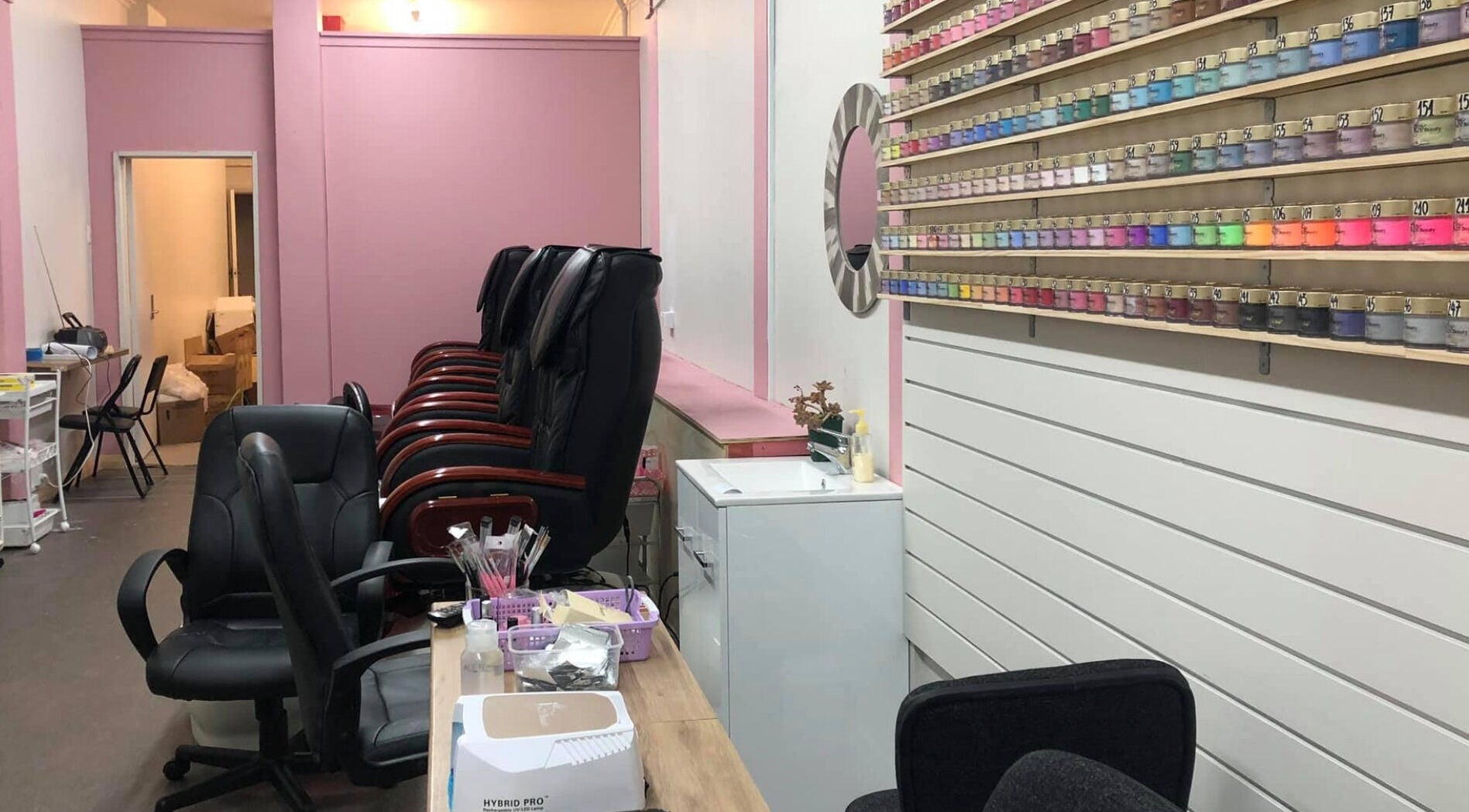 Interior of Ruby Nails, Palmerston North, with colorful nail polish display and comfortable seating.