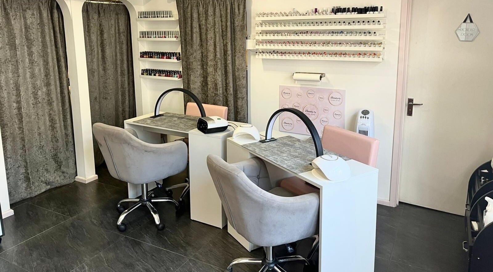 Chic nail stations at Beauty by Laura Jayne in Tutbury, England, GB. Modern decor with chairs and polish displays.