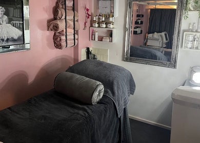 A cozy treatment room at Beauty by Laura Jayne in Tutbury, England featuring plush towels and elegant decor.