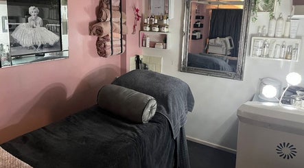 A cozy treatment room at Beauty by Laura Jayne in Tutbury, England featuring plush towels and elegant decor.