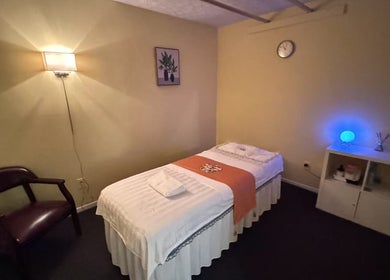 Relaxing massage room at Perfect Massage, Columbus, Ohio, US, featuring a cozy bed and ambient lighting.