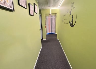 Calming green hallway at Perfect Massage, Columbus, Ohio, US, featuring framed art on the walls.