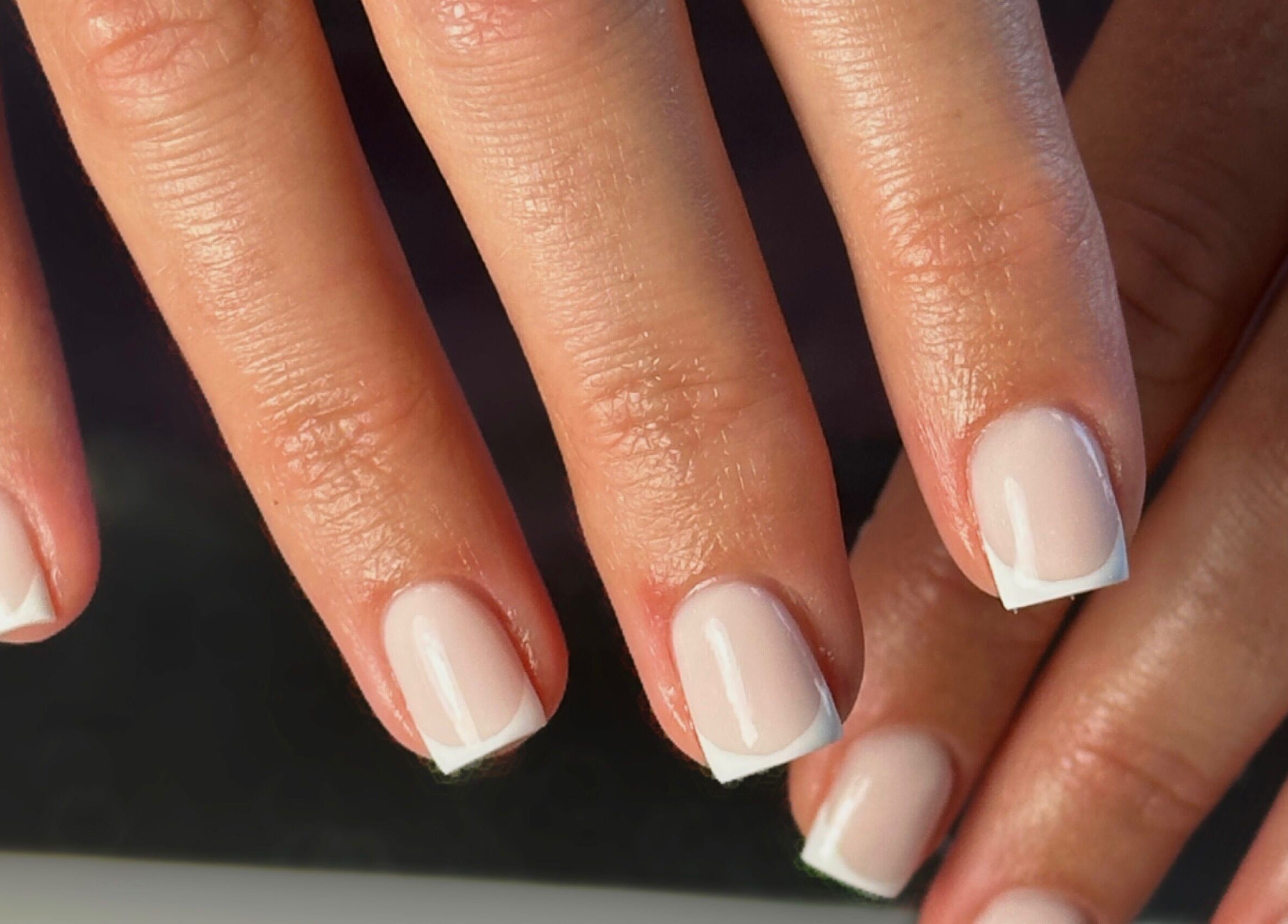 Close-up of elegant French manicure at Shape Studios, Cardiff, Wales, GB showcasing polished nails.