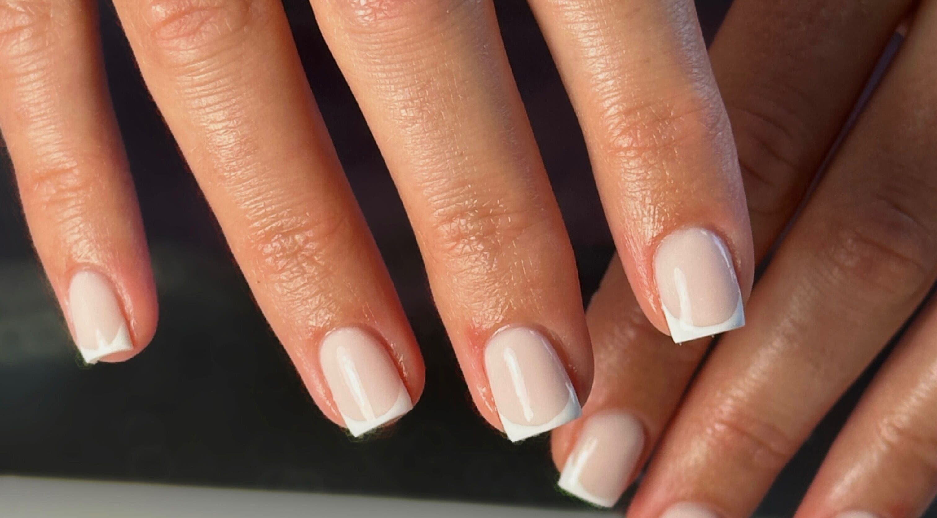 Close-up of elegant French manicure at Shape Studios, Cardiff, Wales, GB showcasing polished nails.