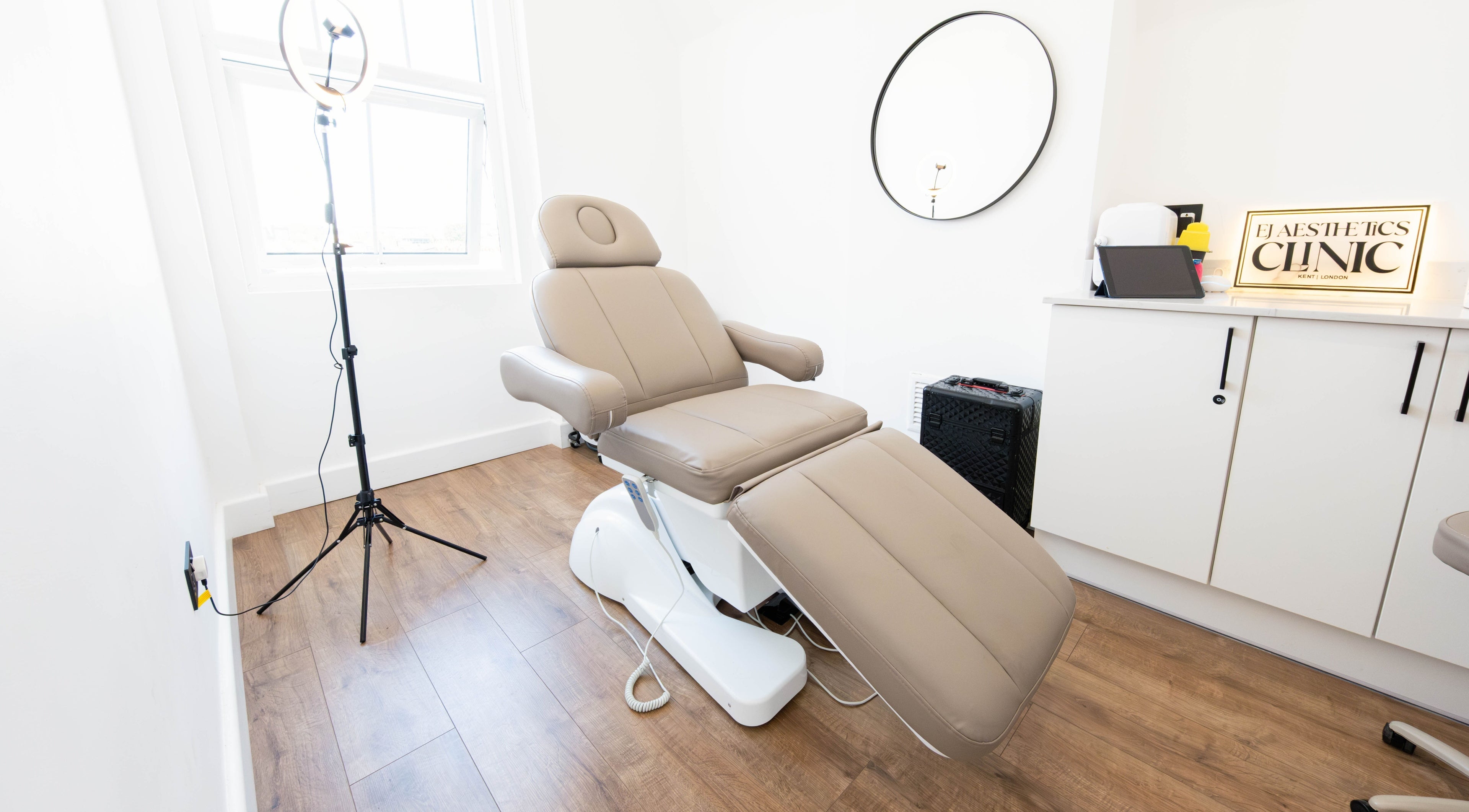 Modern treatment room at Ej Aesthetics Clinic in London, England, GB featuring a comfortable chair and stylish decor.