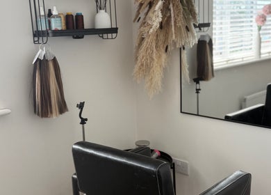 Cozy styling chair at No Audrey’Nary Locks, Tyldesley, England with elegant decor and hair products.