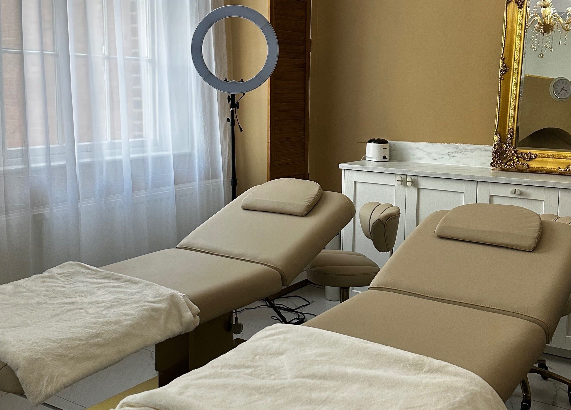Relaxing treatment room at MK Aesthetics Clinic, Derby, England, GB featuring luxury therapy chairs and elegant decor.
