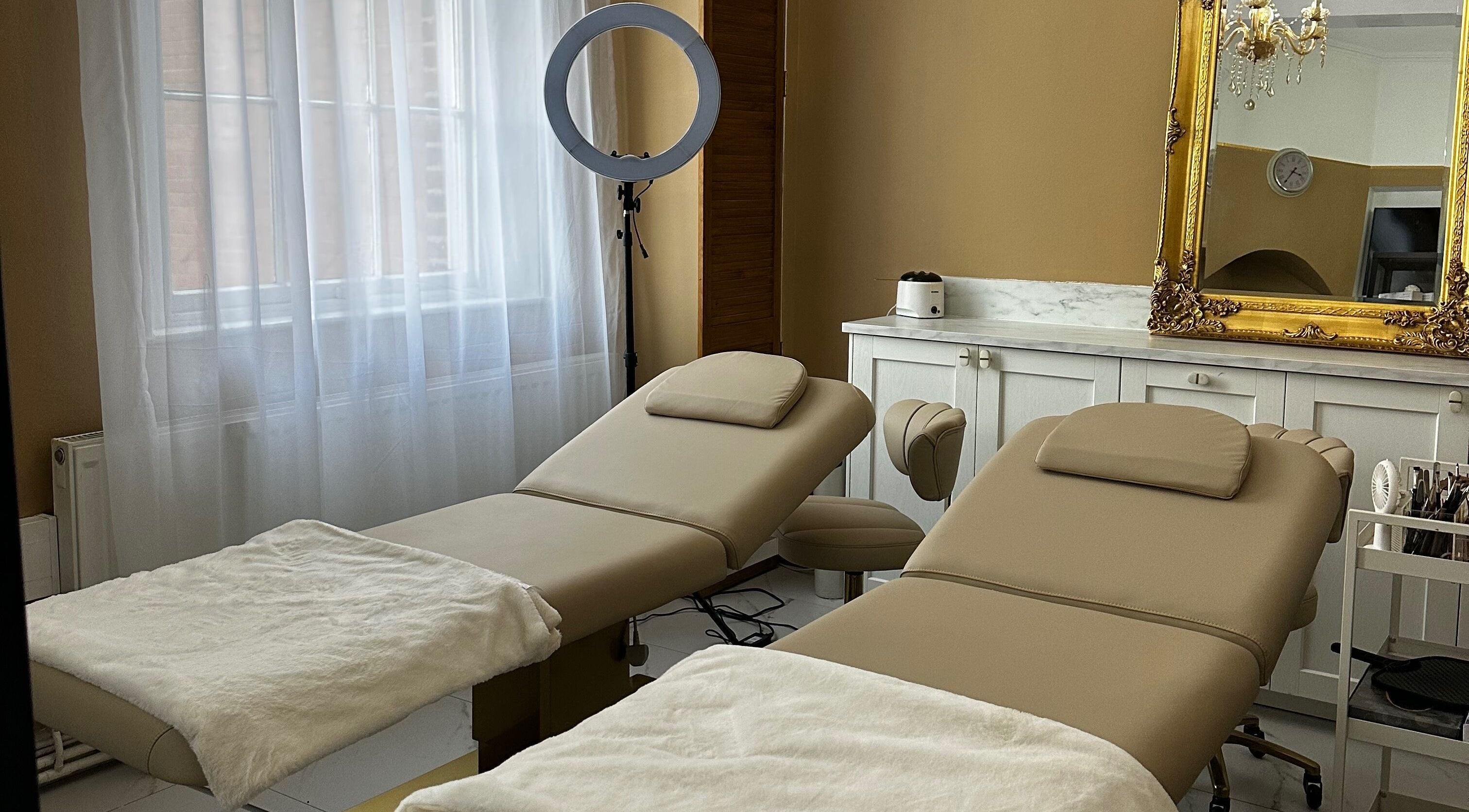 Relaxing treatment room at MK Aesthetics Clinic, Derby, England, GB featuring luxury therapy chairs and elegant decor.
