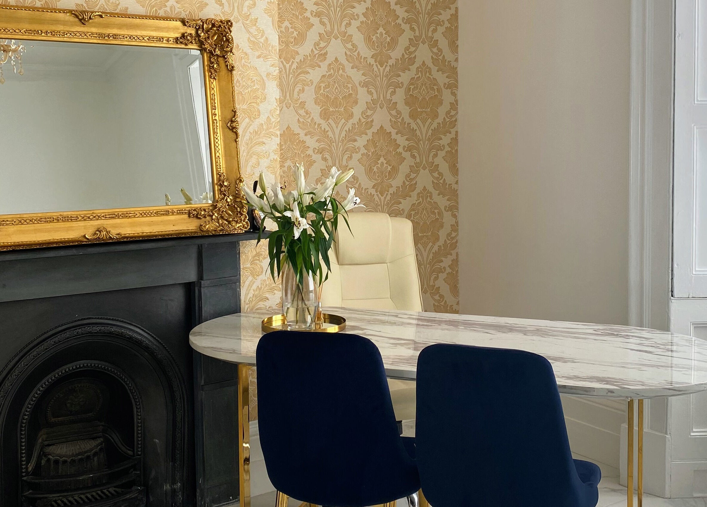 Luxurious seating at MK Aesthetics Clinic, Derby, England, GB with ornate mirror and marble table.