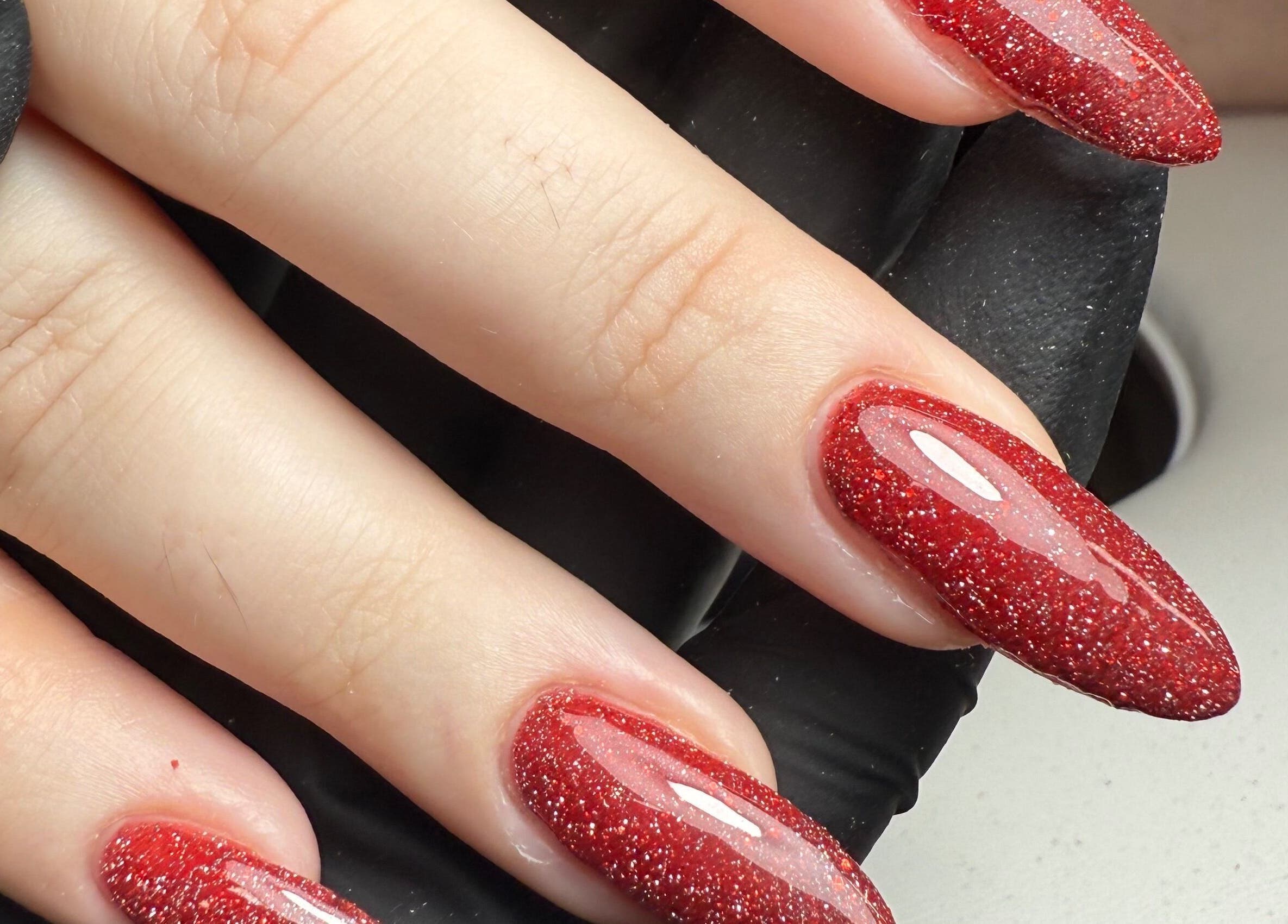Red glitter nails by Beauty By Rebecca, Airdrie, Scotland, GB. Elegant manicure close-up.