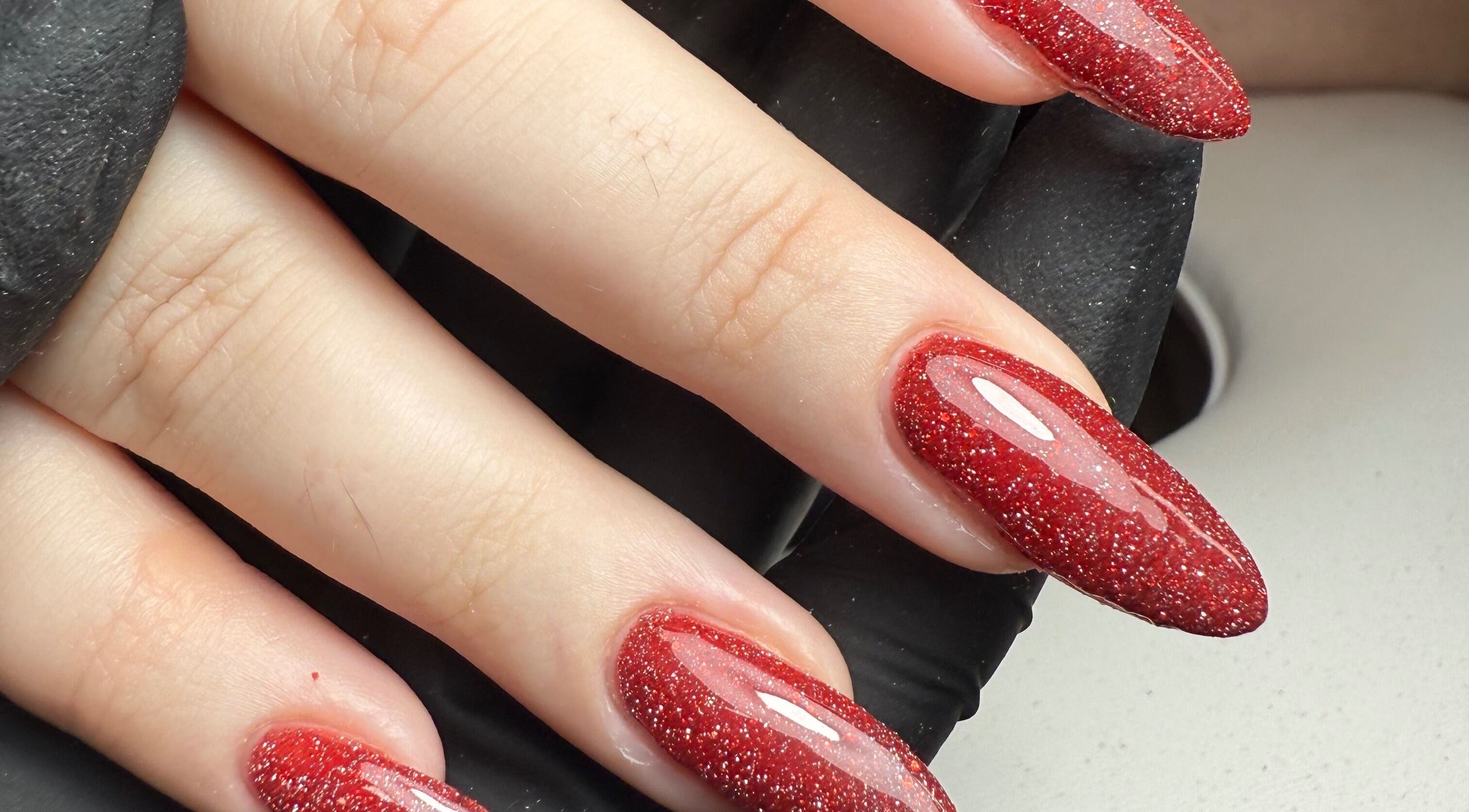 Red glitter nails by Beauty By Rebecca, Airdrie, Scotland, GB. Elegant manicure close-up.