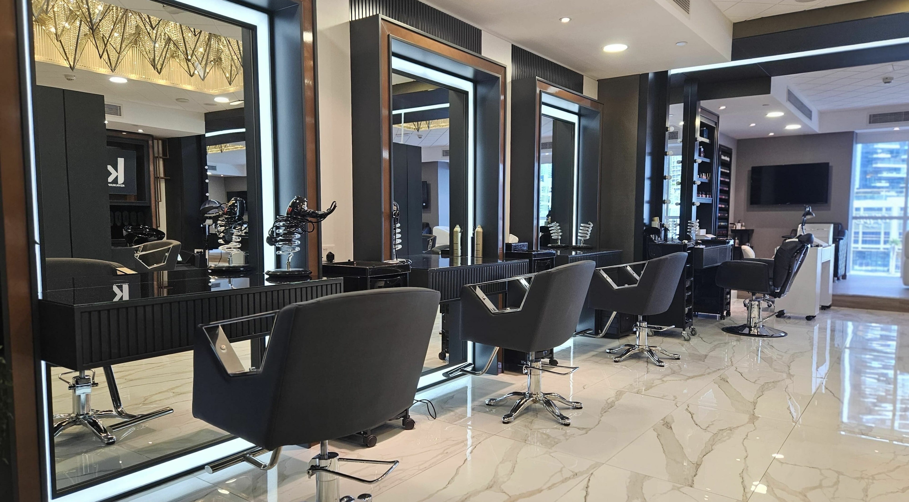 Modern styling area at Yasamir Beauty Lounge in Dubai, Dubai, AE with sleek chairs and large mirrors.